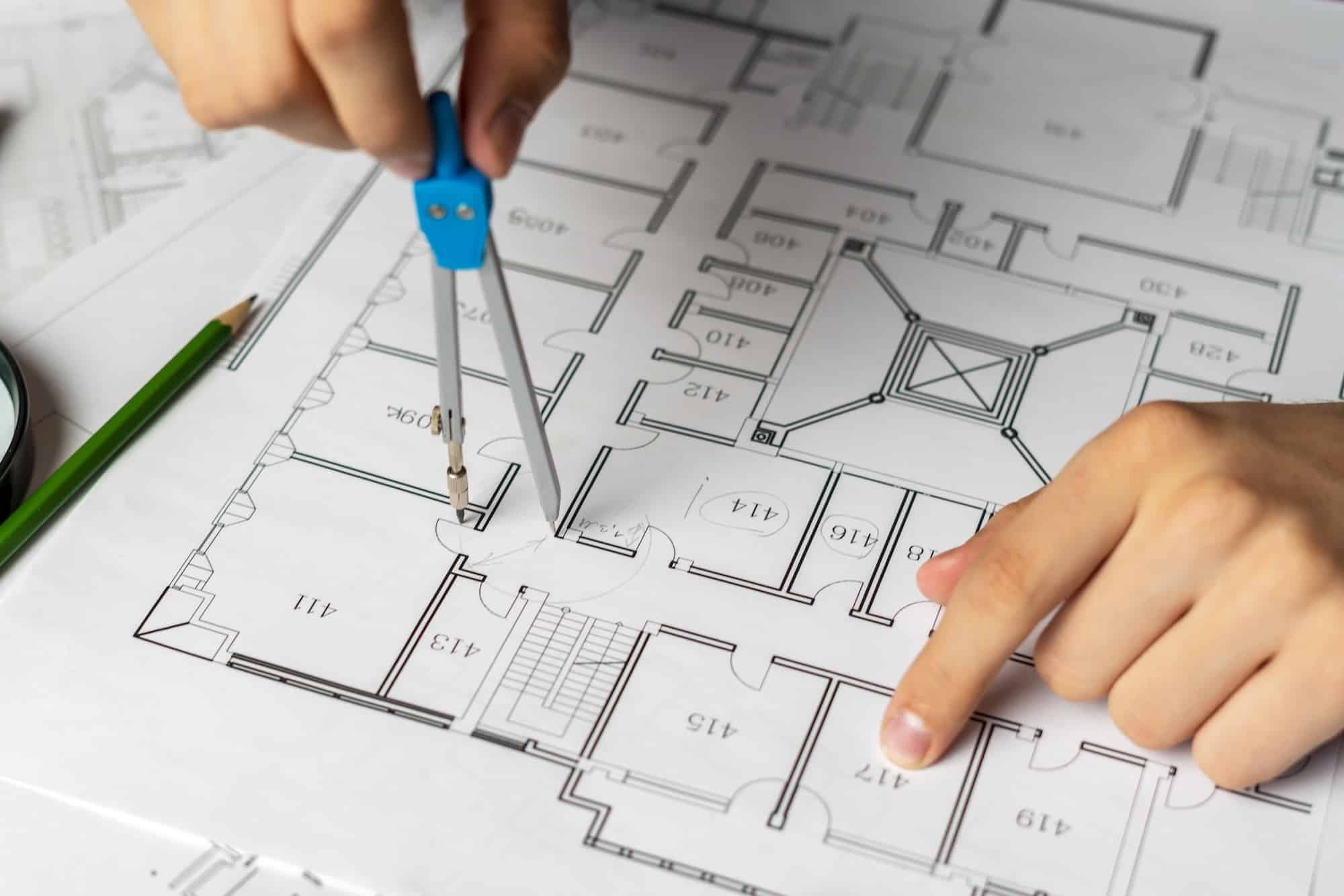 engineer sketching building project on a blueprint with a pencil TGA Beratung TGA Konzept Design trifft Funktionalitaet